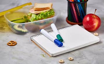 Back to School concept, school supplies, biscuits, packed lunch and lunchbox on white desk, selective focus, close-up.