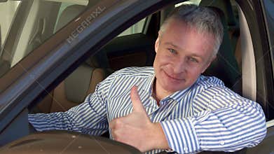 Mature man sits into the car at the dealership