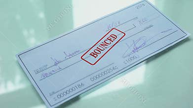 Cheque document bounced, hand stamps seal on official paper, insufficient funds