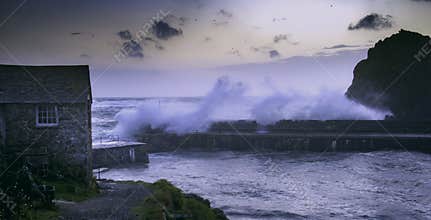 Stormy ocean waves break over harbour wall