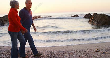 Senior couple walking hand in hand in the beach 4k