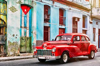 Old car and and building with the cuban flag in Old Havana