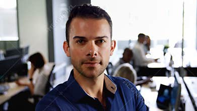 Male executive standing with arms crossed in office