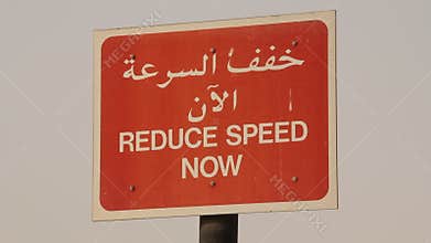 Reduce speed sign in arabic and english