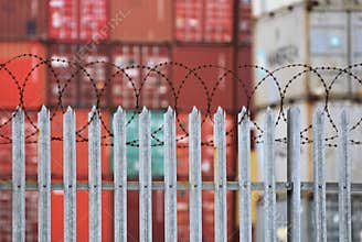 Freight Containers behind a fence topped with barbed wire at the port of Southampton, UK. Jan 2019
