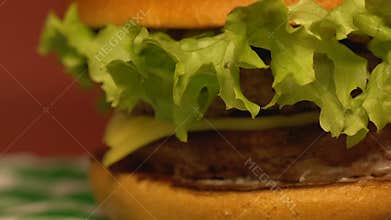 Big delicious double cheeseburger on table in fast food restaurant, close up
