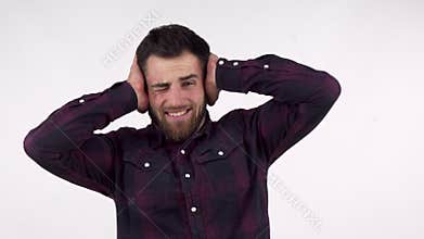 Bearded man covering his ears from a loud noise