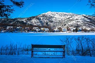 Winter Landscape with A Snowy Bench by A Frozen Lake, Snowy Mountain and Blue Color