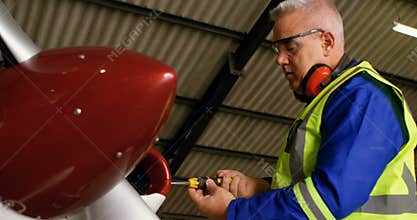 Engineer repairing aircraft at aerospace hangar 4k