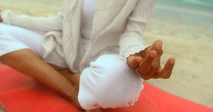 Close-up of active senior African American woman doing yoga on exercise mat at the beach 4k