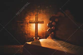 Vintage photo of hand with Bible praying , Hands folded in prayer on a Holy Bible ,