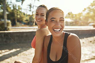 Laughing young women taking a break from an outdoor workout