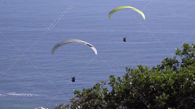 Two paragliders drift in the wind near Cape Town
