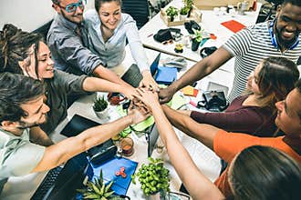 Young employee startup workers group stacking hands at start up office