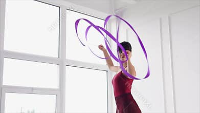 Graceful gymnast performing dance with ribbon