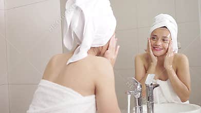 Beautiful woman washing face on faucet