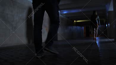 Closeup criminal`s legs chasing victim in darkness