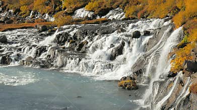 Hraunfossar waterfalls are pouring into Icelandic Hvita river in sunny day in autumn