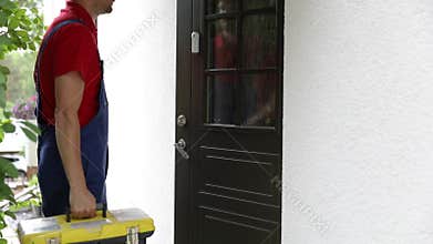Worker with tool box walk to a client house