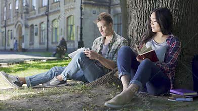 Female and male looking at each other, smiling, guy touches girl, affection