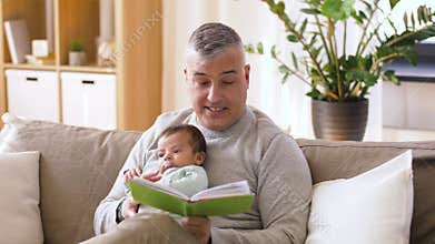 Father reading book for little baby boy at home