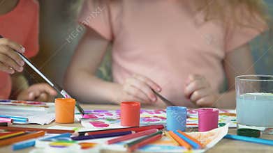 Closeup of two young girls painting a picture at preschool art club, hobby