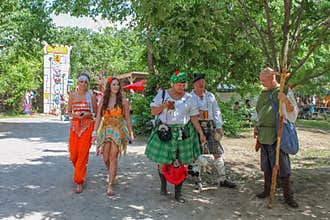 People in costume - two beautiful women in outfits and couple in kilts and man in medieval clothing at Renassiance Festival M
