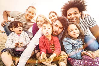 Happy multiracial families taking selfie at beach making funny faces