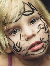 The little girl painted her face with a marker. Makeup for Halloween.