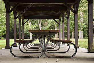 EMPTY PICNIC TABLES UNDER PAVILION