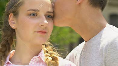 Boy kisses girl, concept of skincare in adolescence, no acne, self-confidence