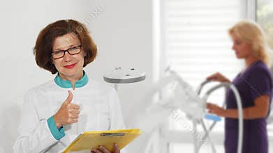 Senior female doctor showing thumbs up posing at the hospital