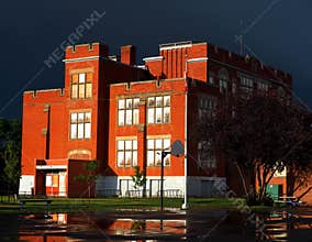 Red Brick School With Dark Storm Clouds And Rain