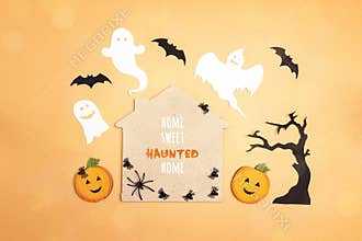 Flat lay Halloween background with cartoon house, spiders,pumpkins and ghosts.