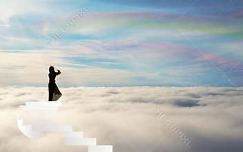 Girl Silhouette on stairs above the clouds rainbow sky straiway to heaven