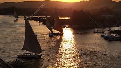 Beautiful felucca boats on Nile river passing by Aswan, Egypt.