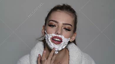 Sexy sensual young woman with foam on the face and a razor blade. Woman shaving face.
