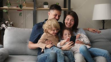 Happy family with kids having fun using smartphone online entertainment