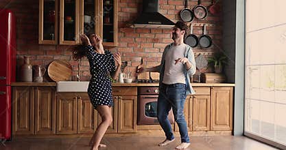Crazy couple having fun dancing in kitchen