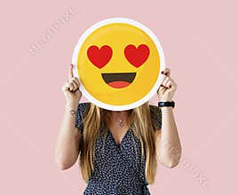 Cheerful woman holding emoticon icon