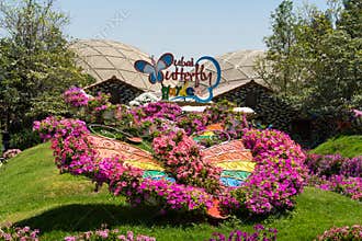 Dubai Butterfly Garden entrance way of floral design to sign of nature tourist attraction on sunny day