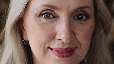 Close up beautiful 50s woman smiling looking at camera