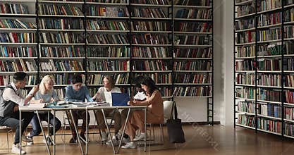 Group of multi ethnic classmates studying sit in spacious library