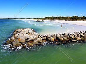 Beautiful blueish green water, white beach and rocky area near Fort De Soto State Park, St Petersburg, Florida, U.S