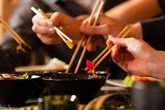 Young people eating in Thai restaurant
