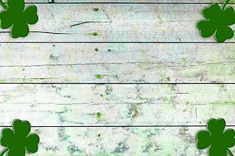 St Patricks day background. Shamrocks over a light green wood background