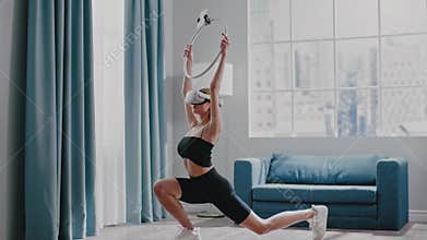 Lady in tracksuit does dynamic lunges with VR headset