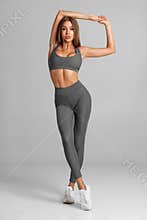 Beautiful fitness woman on gray background