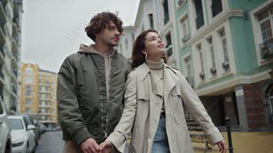 Happy couple walking in old town. Man and woman enjoying city walk outdoor.