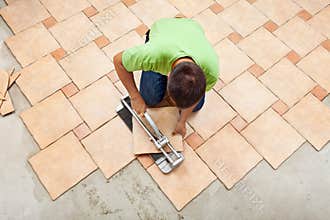 Man laying ceramic floor tiles